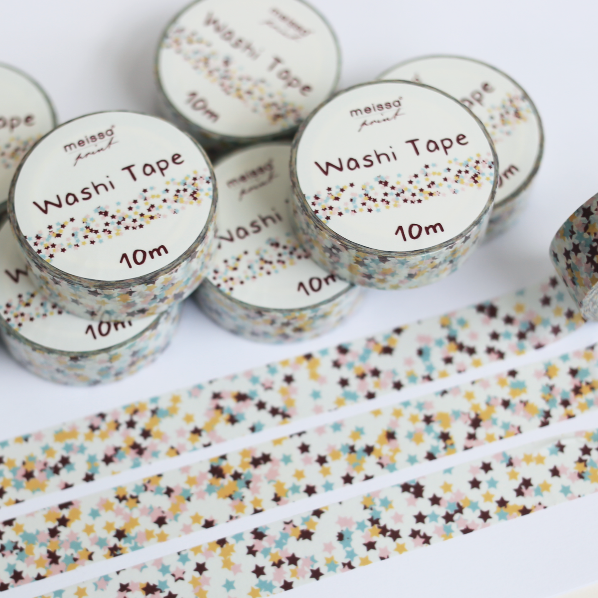 Multiple rolls of Meiso Paper washi tape with a multicolor star confetti pattern, shown with several strips unrolled on a clean white background.